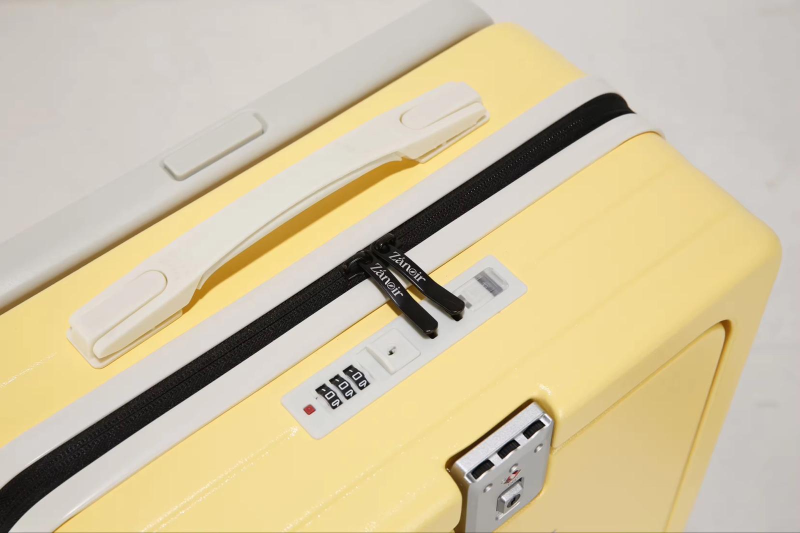 Close-up of sunrise yellow suitcase zipper with brand logo