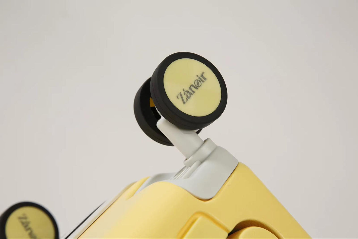 Close-up of sunrise yellow carry-on suitcase wheel with brand logo