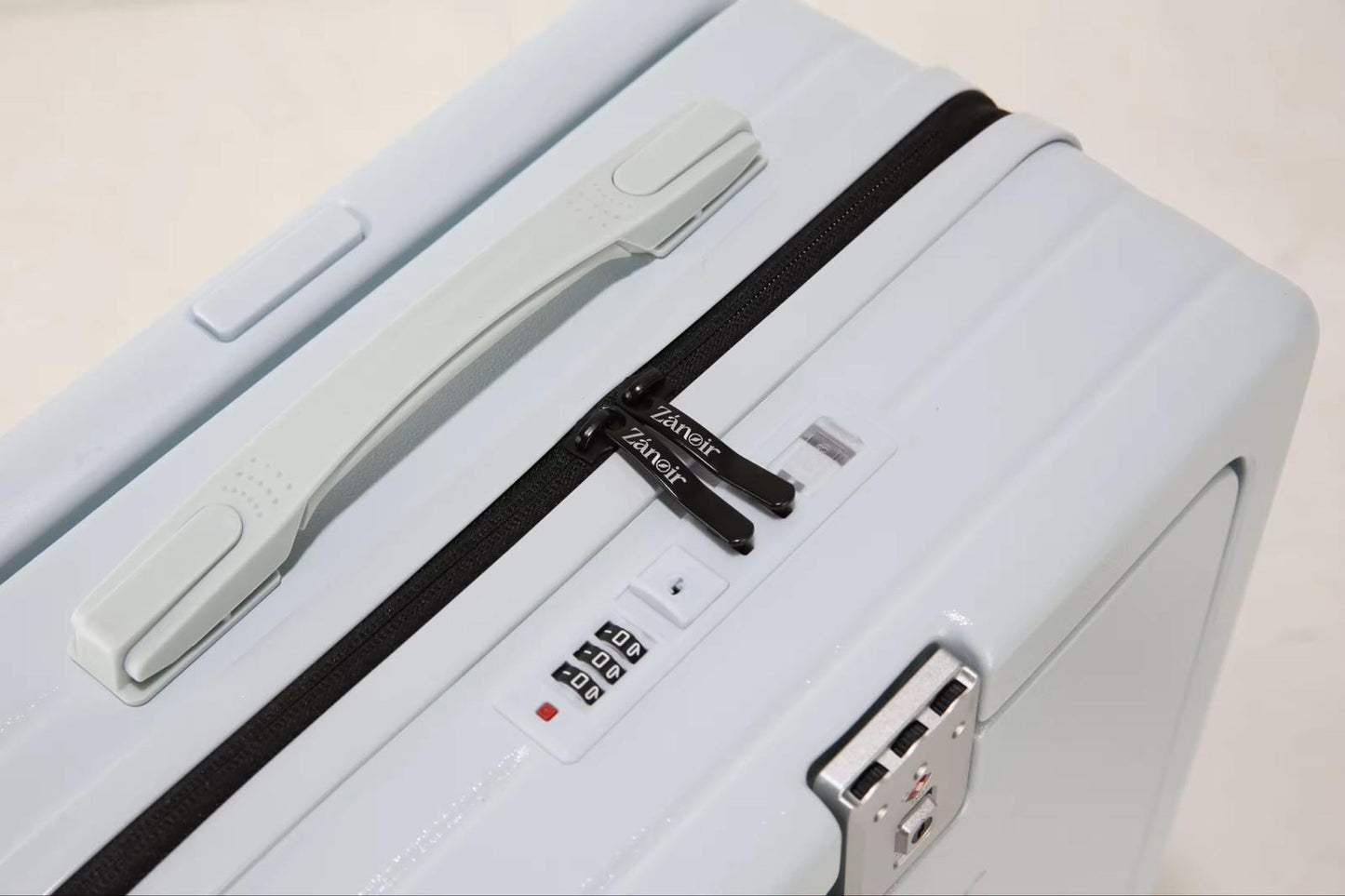 Close-up of ocean blue suitcase zipper with brand logo