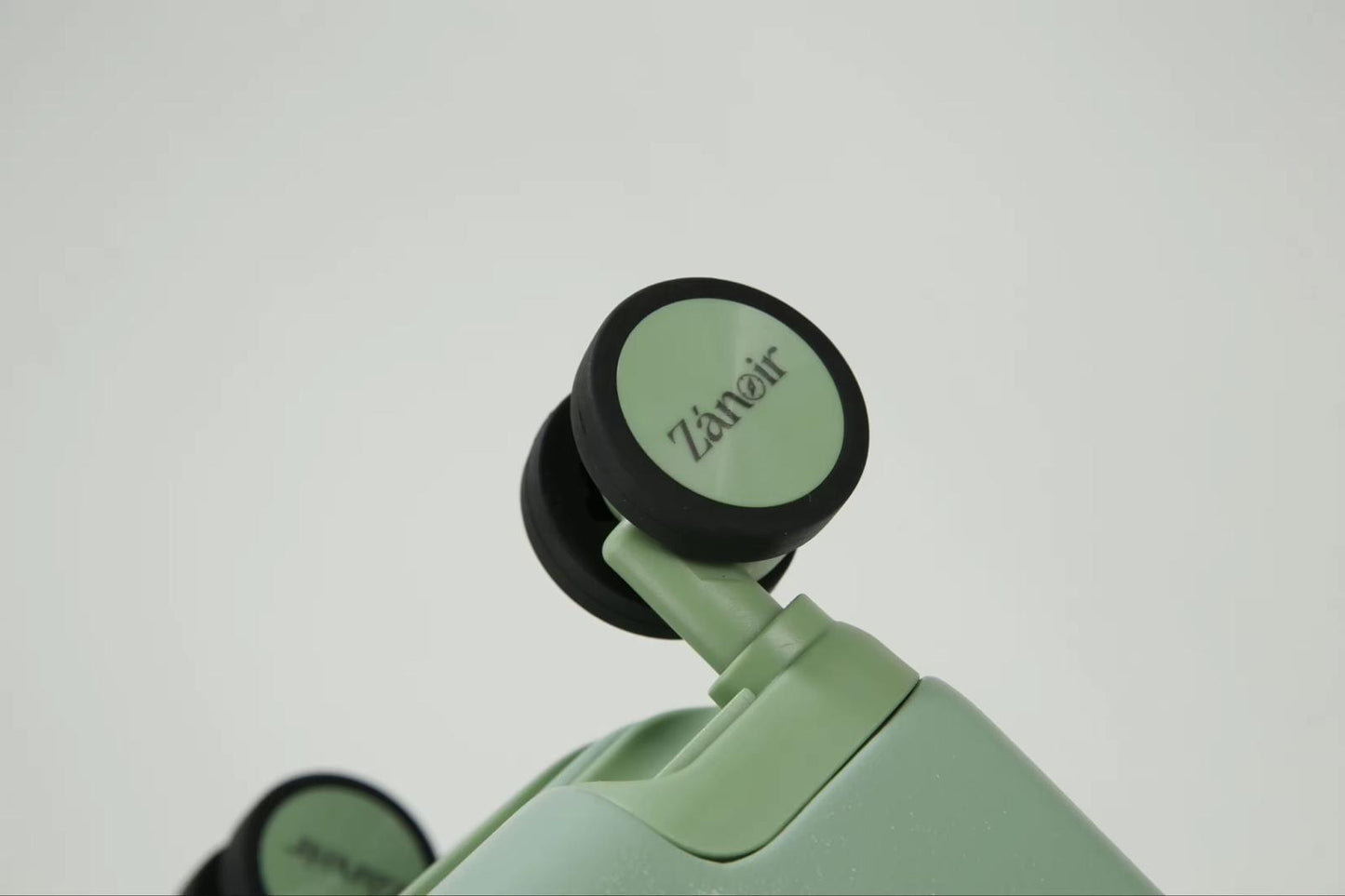 Close-up of forest green carry-on suitcase wheel with brand logo